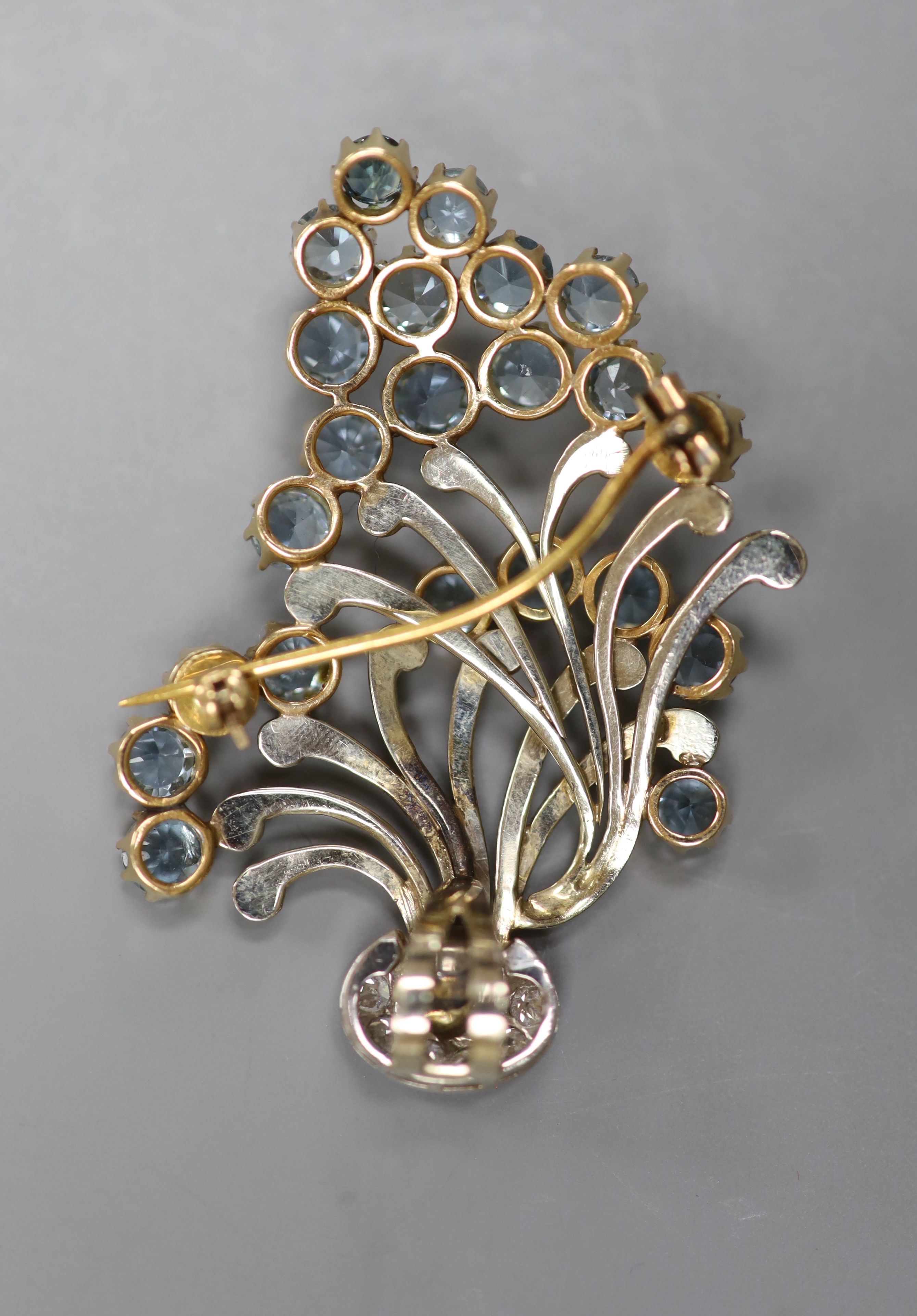 A 1950's yellow and white metal, aquamarine and diamond cluster set floral spray brooch